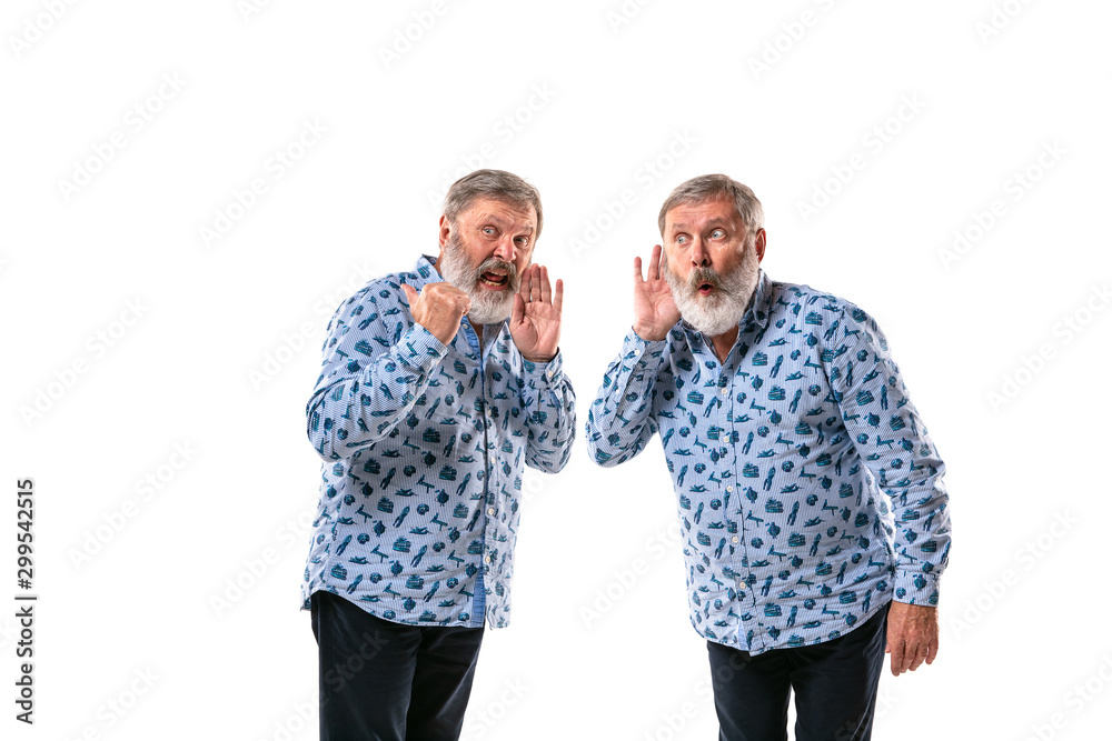 Senior man arguing with himself on white studio background. Concept of human emotions, expression, mental issues, internal conflict, split personality. Half-length portrait. Negative space. Secret. Senior man arguing with himself on white studio background. Concept of human emotions, expression, mental issues, internal conflict, split personality. Half-length portrait. Negative space. Secret.