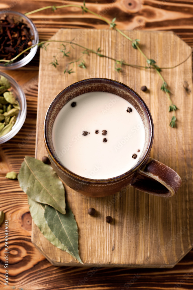 Masala tea with cinnamon, cloves, bay Indian tea with spices. Masala tea. National cuisine, cardamom, thyme, black pepper on a wooden table. Indian food. National cuisine. Breakfast Masala tea with cinnamon, cloves, bay Indian tea with spices. Masala tea. National cuisine, cardamom, thyme, black pepper on a wooden table. Indian food. National cuisine. Breakfast