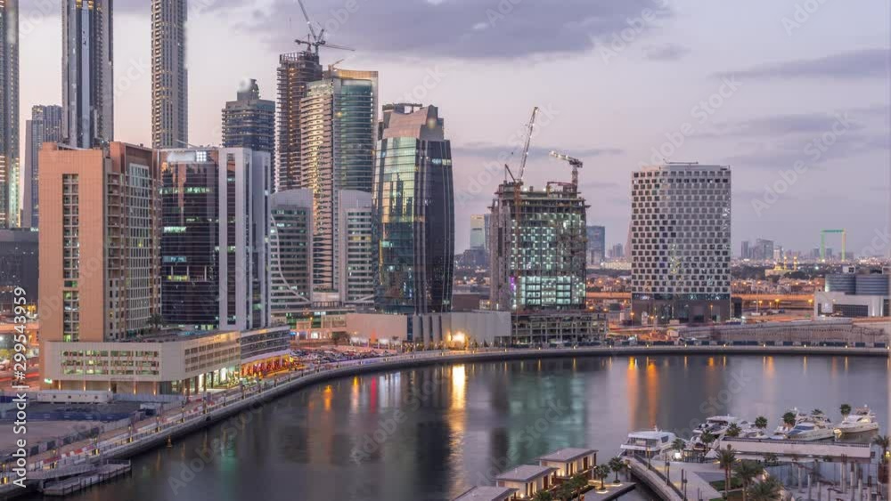 Futuristic skyscrapers after sunset near beautiful river with luxury yachts in Business Bay aerial day to night transition timelapse, Dubai, United Arab Emirates Futuristic skyscrapers after sunset near beautiful river with luxury yachts in Business Bay aerial day to night transition timelapse, Dubai, United Arab Emirates