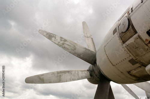 Fotografie Part of the fuselage of the old military plane with the propeller closeup against the background of an empty and gray sky