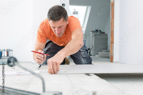 Foto Fliesenleger bei der Arbeit , handwerker schneidet fliesen mit schneidetisch we