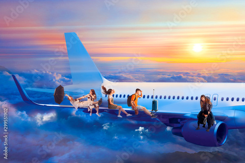 Tourists fly on vacation and sitting on wing of jet passenger airplane at evening sunset