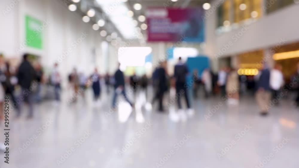 Blurred crowd of people passing by in a conference hall Blurred crowd of people passing by in a conference hall