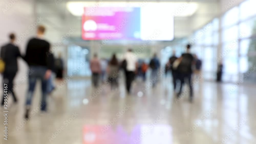 Blurred crowd of people passing through shot in one direction at a conference Blurred crowd of people passing through shot in one direction at a conference