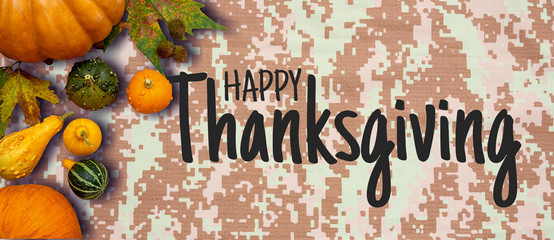 Happy Thanksgiving flat lay with colorful pumpkins and fruits on army digital pattern textile