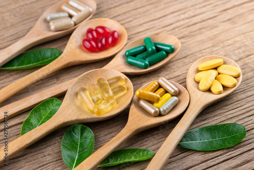 Alternative herbal medicine, vitamin and supplements from natural, pills and capsules on rustic wood background, drug concept