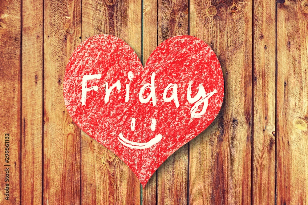 Heart sign with word Friday on wooden desk Heart sign with word Friday on wooden desk