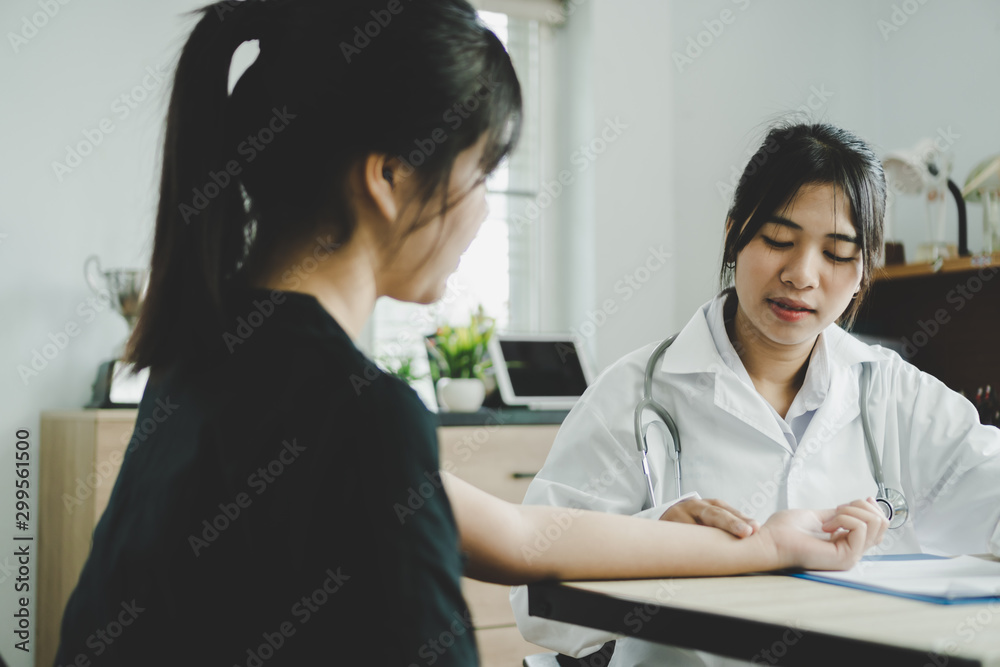 Asian doctor measuring patient pulse for checking measure pulse in annual health check,Medical student on treatment in desk prescription clipboard consultation with gown stethoscope in clinic hospital Asian doctor measuring patient pulse for checking measure pulse in annual health check,Medical student on treatment in desk prescription clipboard consultation with gown stethoscope in clinic hospital