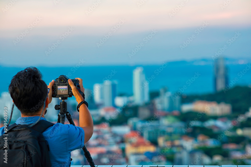 Obraz premium Senior male tourist using professtional camera (Dslr) taking a photo of Pattaya view. Chonburi, Thailand.