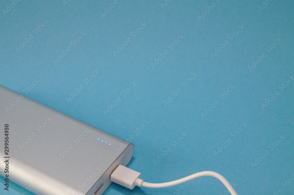 Obraz premium Isolated silver powerbank on a blue background