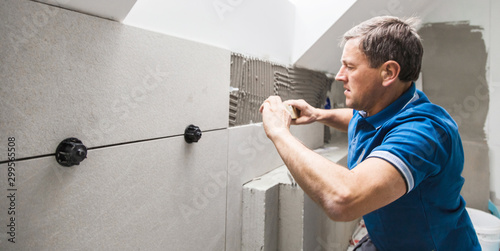 Tiler installing large format tile on wall. home indoors renovation photo