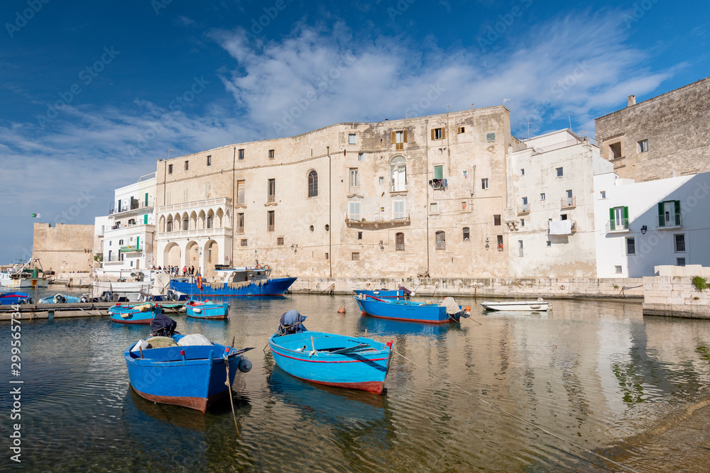 View of Monopoli harbor with colorful azure fishing boats, Apulia, Italy.