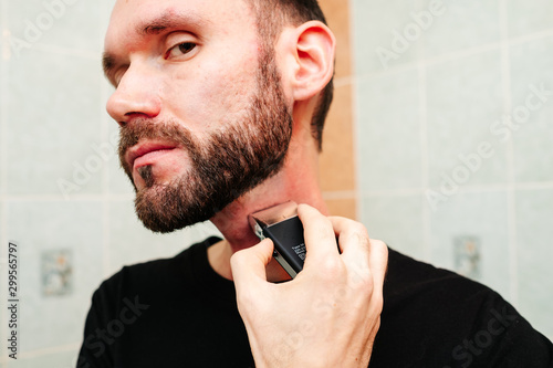 Man snarling at razor with shaving cream and towel