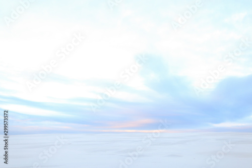White winter steppe and sky with clouds.