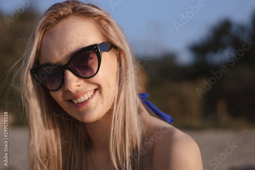 happy young woman in a swimsuit and suglasses walking on the beach,  model posing