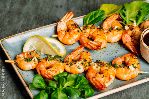 Delicious roasted shrimps on plate with lemon