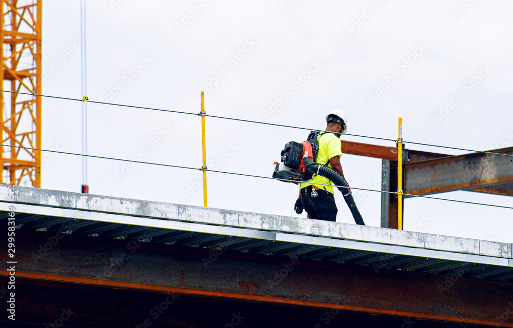 Construction worker working on the site with a vacuum cleaner