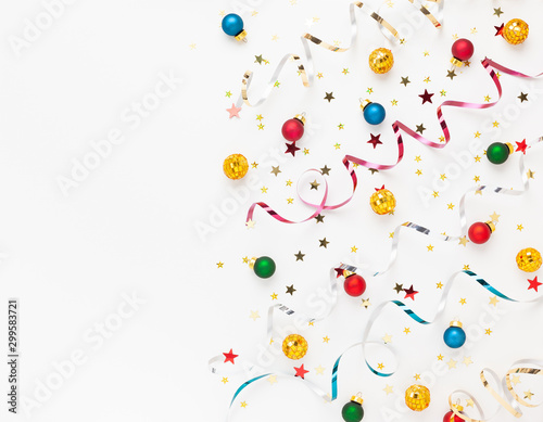  Festive composition with colorful confetti  Christmas ornaments and streamers on white. Celebration concept ideas for Christmas  New Year.