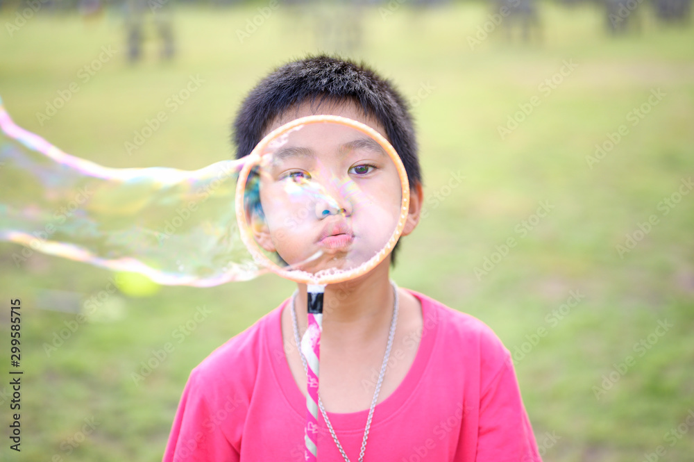 Cute Asian Kid making soap bubbles outside, summer time. Cute Asian Kid making soap bubbles outside, summer time.