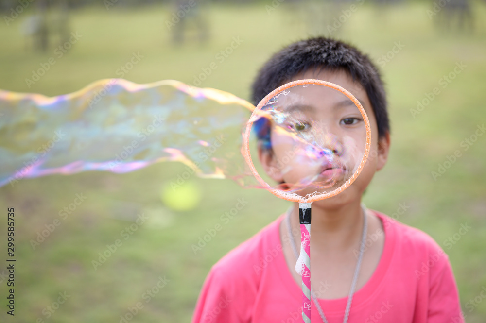 Cute Asian Kid making soap bubbles outside, summer time. Cute Asian Kid making soap bubbles outside, summer time.