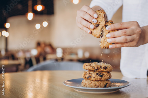 close up photo of delicious and crunchy oatmeal cookies on the backdrop of a cozy restaurant or bakery interior, festive Christmas mood, 4 cookies lying on top of each other