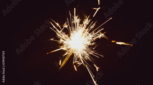 Sparkler isolated on dark background. Lots of bright sparks.
