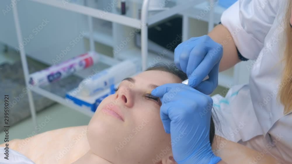 Beautician removes curlers from lashes after lamination lifting procedure in beauty salon, face closeup. Cosmetologist making lash lifting in cosmetology clinic, hands closeup. Beautician removes curlers from lashes after lamination lifting procedure in beauty salon, face closeup. Cosmetologist making lash lifting in cosmetology clinic, hands closeup.