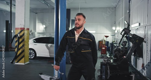 great day for a mechanic man dancing funny at work while checking the car engine in front of the camera