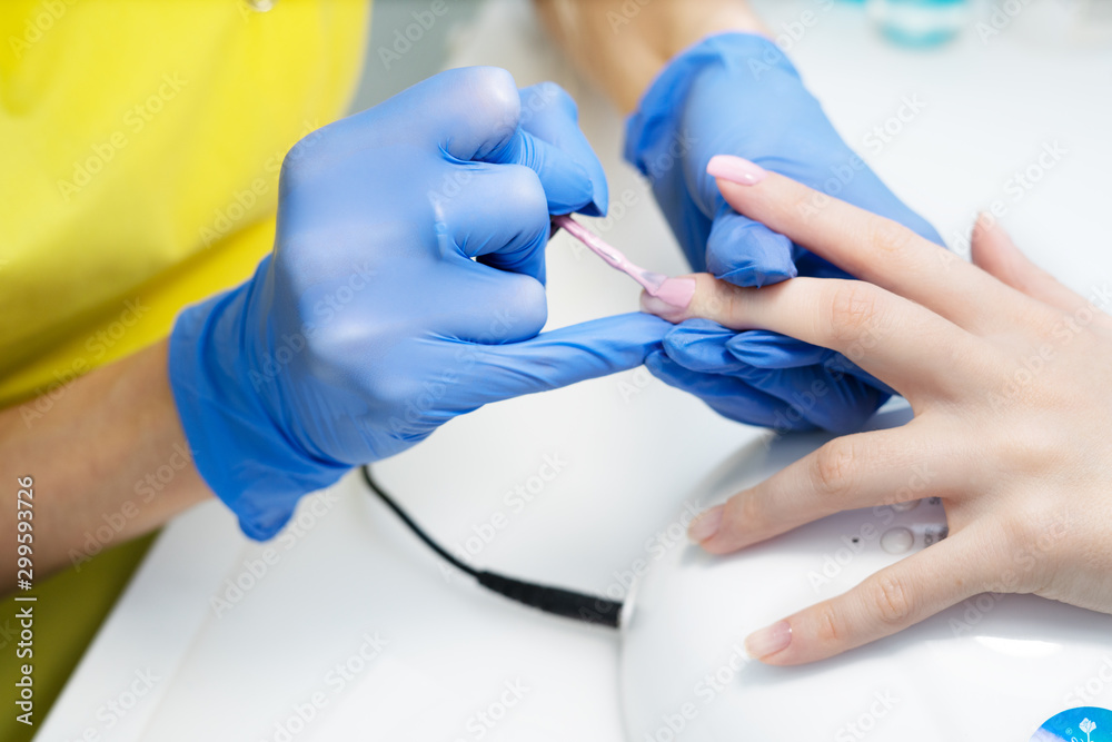 Nail care. Manicure in the salon. The master manicures the girl, beauty and health. Manicure process. Master in mask and gloves. Nail polish. Nail care. Manicure in the salon. The master manicures the girl, beauty and health. Manicure process. Master in mask and gloves. Nail polish.
