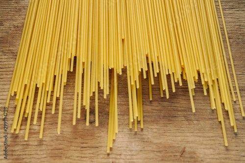 Yellow long spaghetti on a black background. Yellow Italian pasta. Long spaghetti. Raw spaghetti bolognese. Raw spaghetti. Food concept background. Italian food and menu concept.