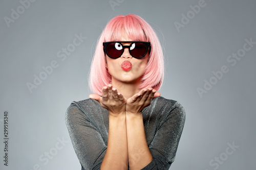 Obraz na plátně style, fashion and people concept - happy young woman in pink wig and black sung