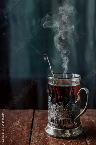 Fotografija A glass of hot black tea in a vintage cup holder