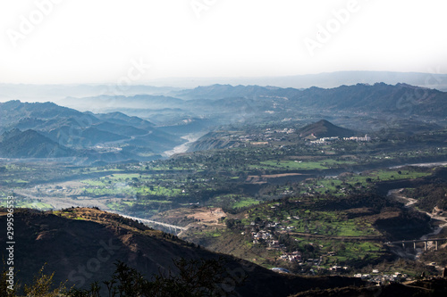 Fog covered mountain range and river in a wide shot from a hill top