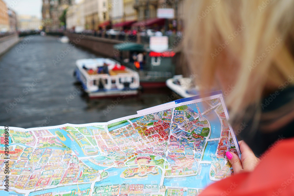 Girl travels with a map on a city street, concept- travel to historical places Girl travels with a map on a city street, concept- travel to historical places