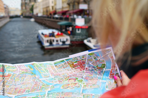 Girl travels with a map on a city street, concept- travel to historical places
