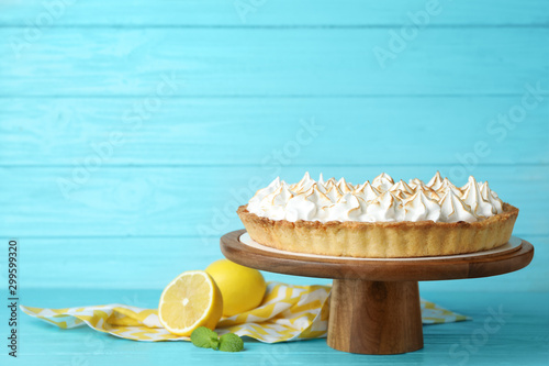 Stand with delicious lemon meringue pie on blue wooden table, space for text photo