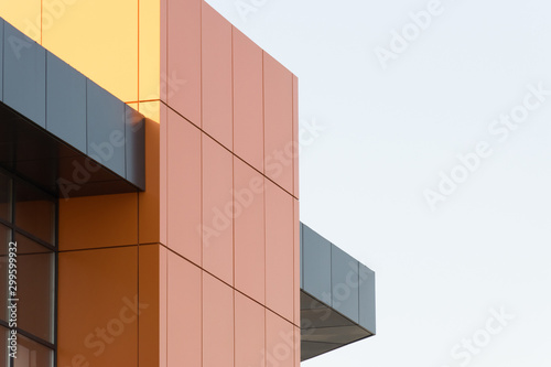 Geometric color elements of the building facade with planes  lines  corners with highlights and reflections for an abstract background and texture of gray  orange colors. Place for text