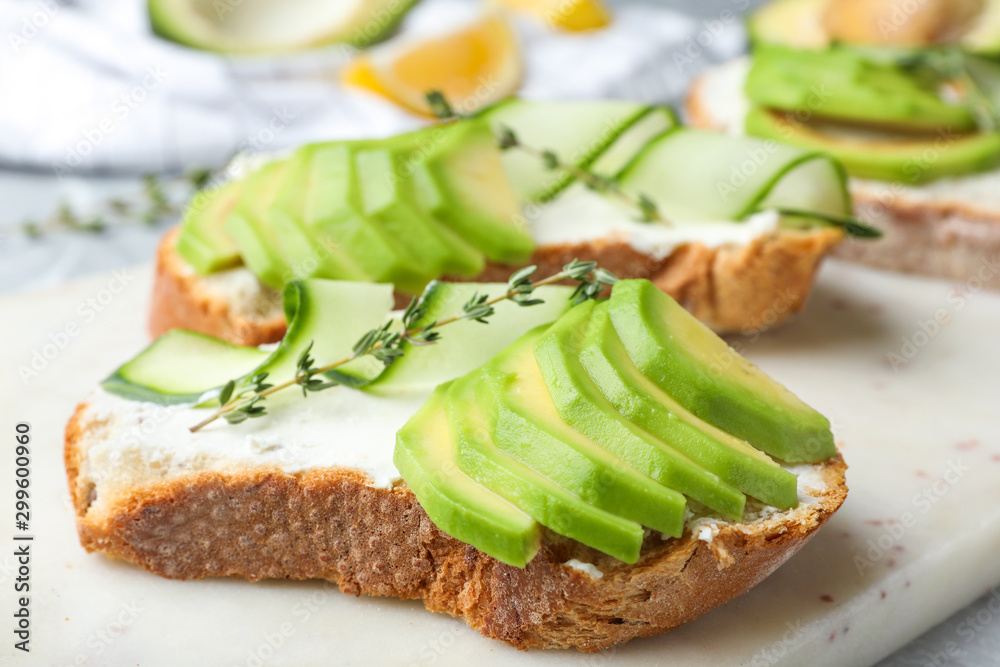 Tasty sandwiches with avocado and cucumber on table, closeup Tasty sandwiches with avocado and cucumber on table, closeup