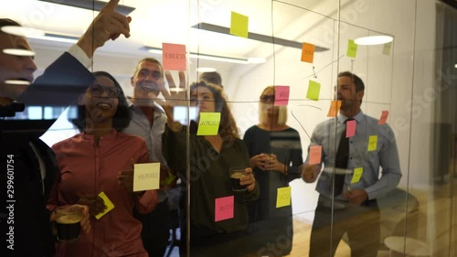 Smiling businesspeople brainstorming together with sticky notes in an office