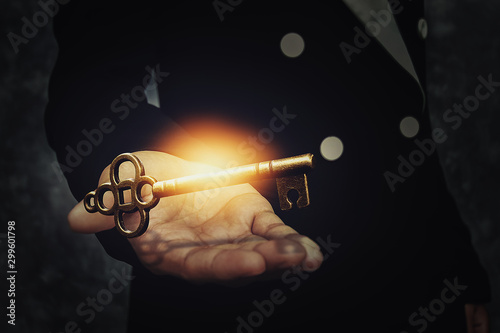 Close up image of a business person holding a shining key. Success business concept