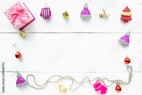 Christmas background top view. Pink and red gift boxes. Coniferous branches and Christmas toys on a background of a white wooden board. New Year 2020