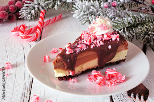 Christmas holiday candy cane chocolate cheesecake. Side view scene with a white wood background. photo