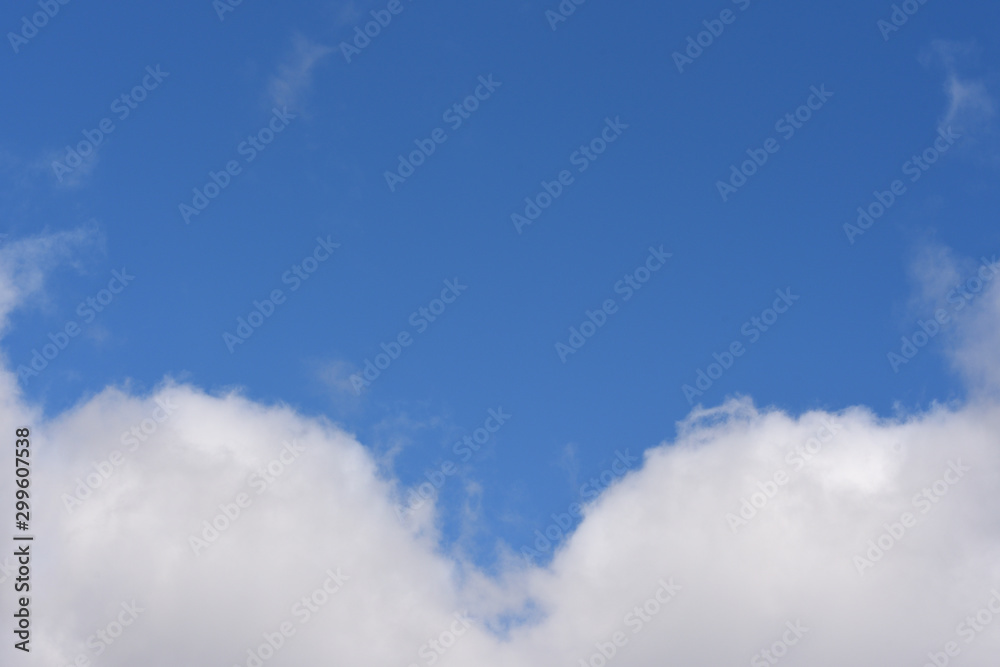 Beautiful fluffy clouds with symmetric pattern on a blue sky background with place for text Beautiful fluffy clouds with symmetric pattern on a blue sky background with place for text