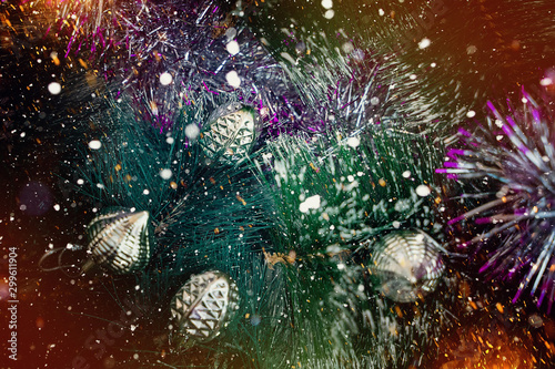 Beautiful christmas background with christmas tree and christmas balls. In the background there are rays of the sun and snowflakes. Modern design. Background, texture