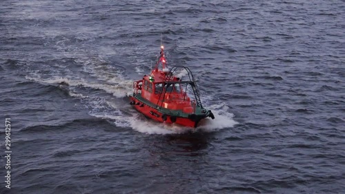 small red fast pilot motor ship from Riga harbor port sails on blue water to accompany tanker Onyx close view photo