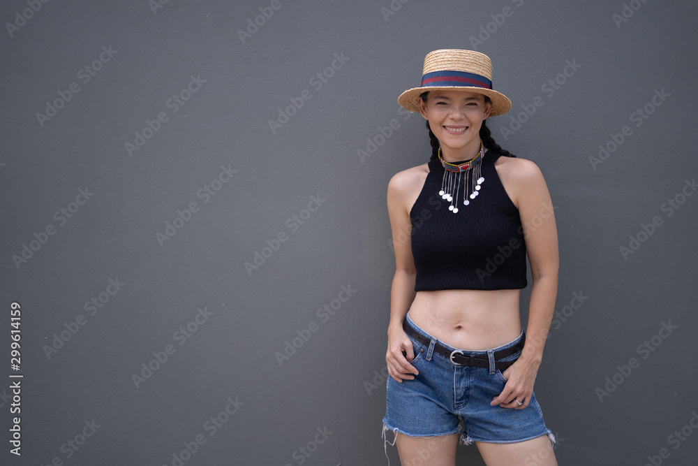 Beautiful Asian women wearing straw hats and black sleeveless tops. Denim shorts Gray backdrop Beautiful Asian women wearing straw hats and black sleeveless tops. Denim shorts Gray backdrop