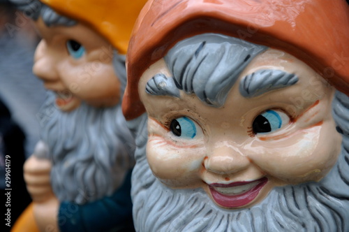 Tablou pe pânză Two gnomes with orange hats add a mischievous flair to the spring garden