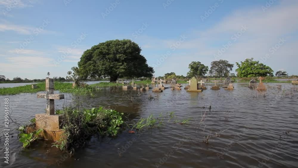 City cemetery and cross tombs full of water during big floods in the Amazon river basin. Natural disaster, flood, climate change and environment concept. Manaus, Amazonas, Brazil - July 05, 2012. City cemetery and cross tombs full of water during big floods in the Amazon river basin. Natural disaster, flood, climate change and environment concept. Manaus, Amazonas, Brazil - July 05, 2012.