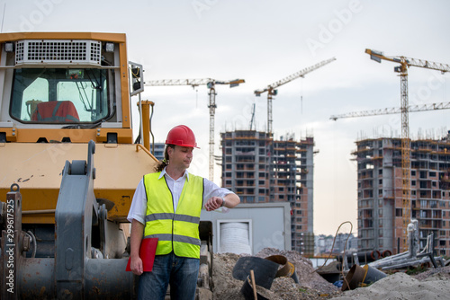 Construction site engineer looking at the time on his watch