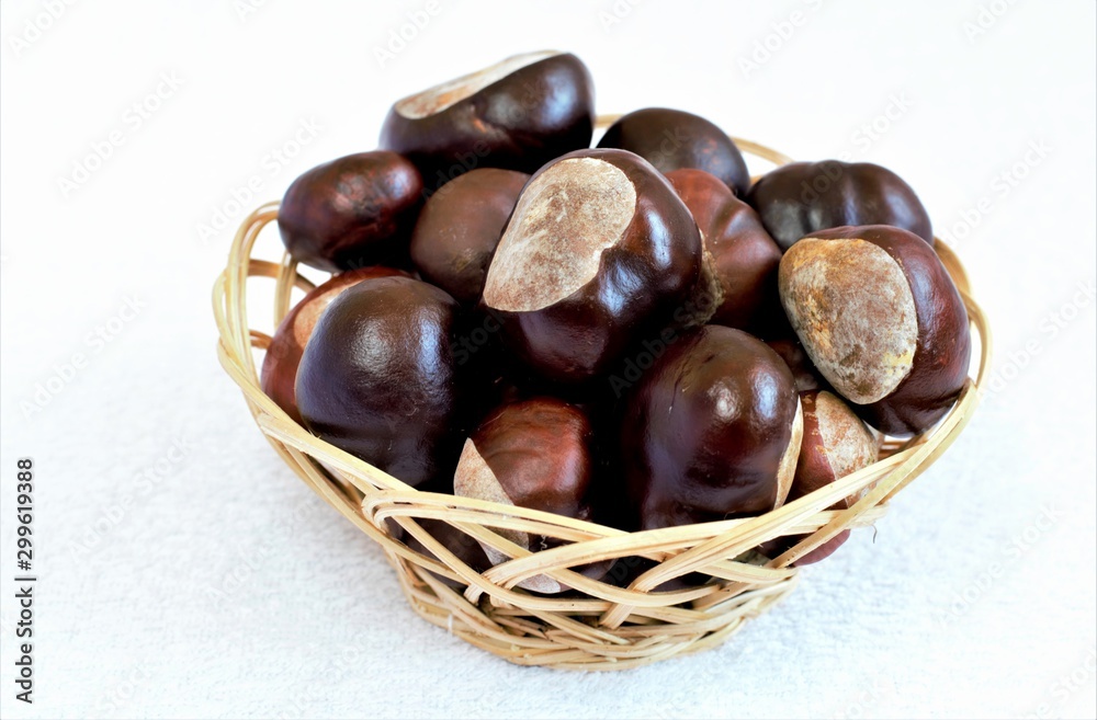 Chestnuts in a basket on a white background Chestnuts in a basket on a white background
